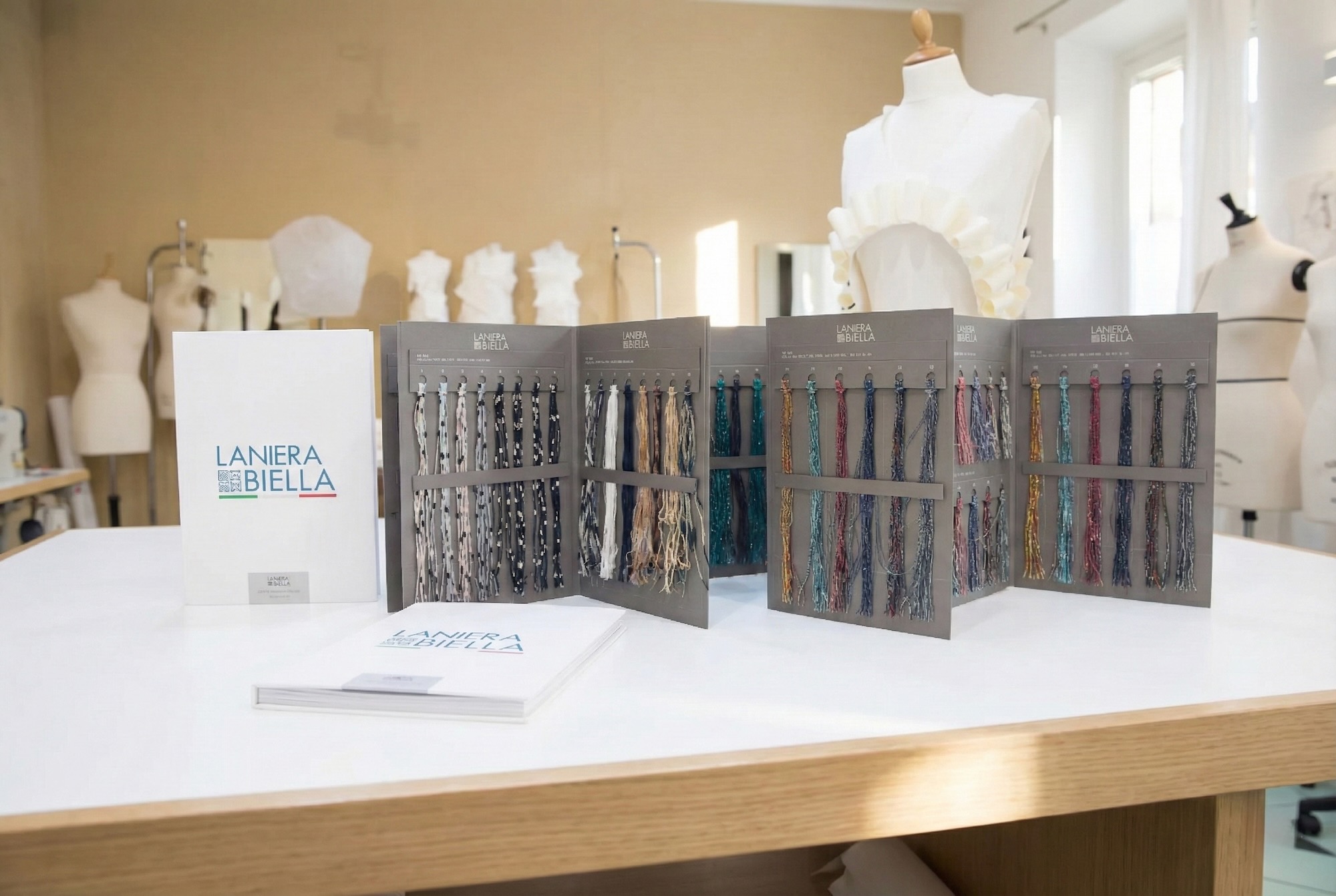 Cartelle campioni Laniera Biella su tavolo atelier