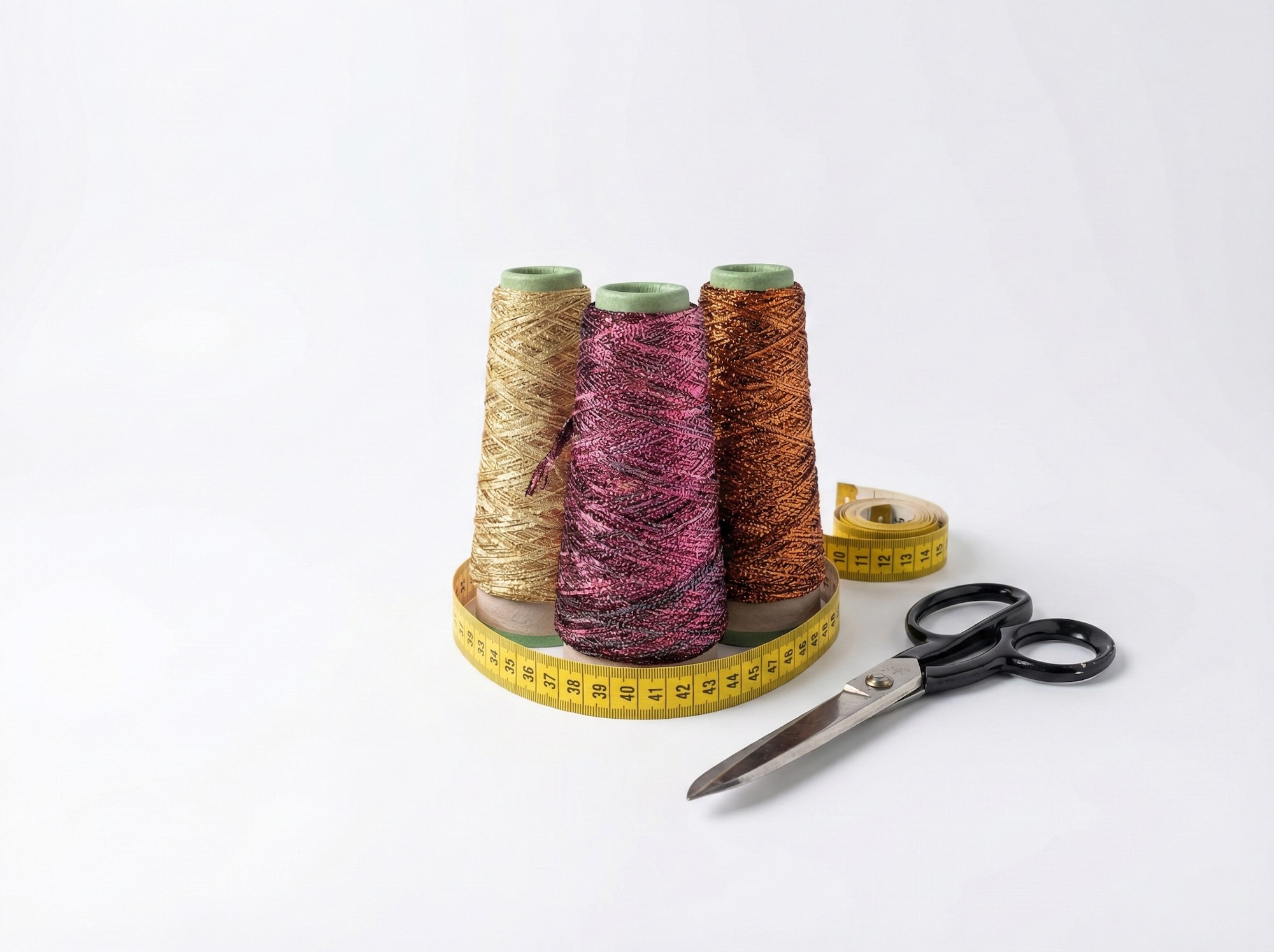 Filati metallizzati oro, rosa e rame su rocchetti