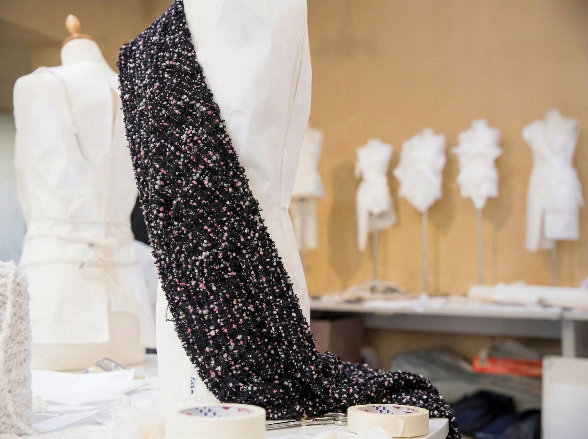 Tessuto tweed nero drappeggiato su manichino in atelier