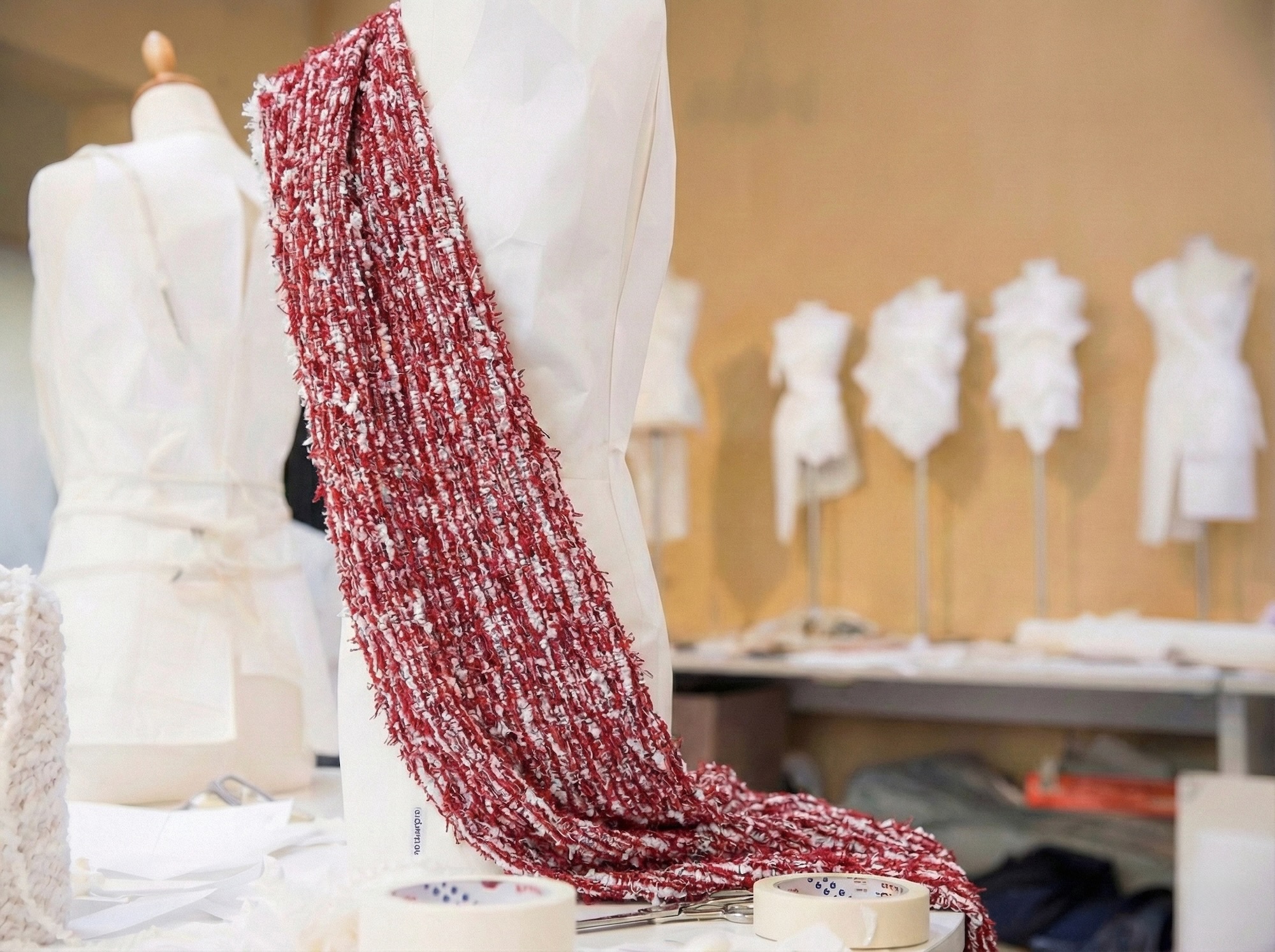 Tessuto tweed rosso e bianco su manichino in atelier